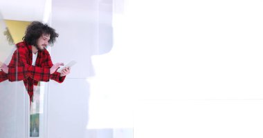 Genç adam evde tablet kullanıyor.