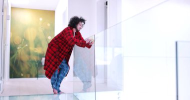 Genç adam evde tablet kullanıyor.