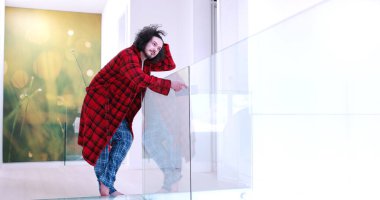 Genç adam evde tablet kullanıyor.