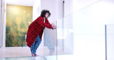 Genç adam evde tablet kullanıyor.