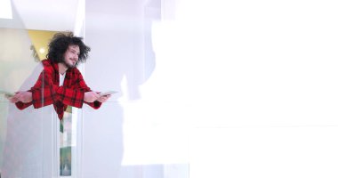 Genç adam evde tablet kullanıyor.