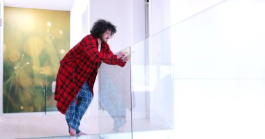 Genç adam evde tablet kullanıyor.