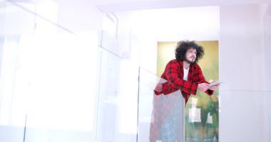 Genç adam evde tablet kullanıyor.