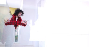 Genç adam evde tablet kullanıyor.