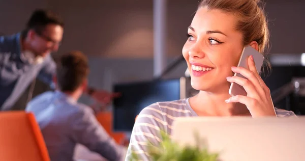 Femme utilisant un téléphone portable dans le bureau sombre — Photo