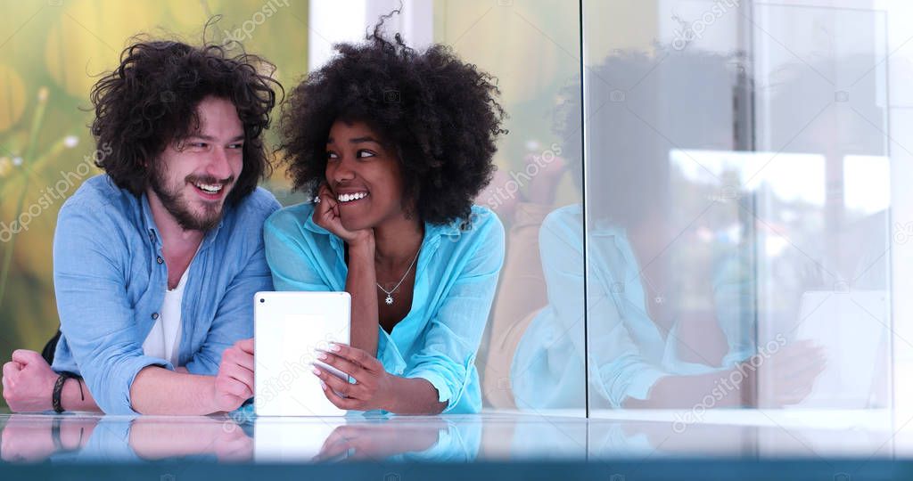 Couple relaxing together at home with tablet computer