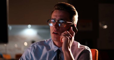 karanlık ofisinde cep telefonu kullanan adam