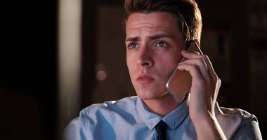 karanlık ofisinde cep telefonu kullanan adam