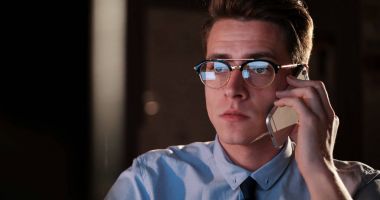 karanlık ofisinde cep telefonu kullanan adam