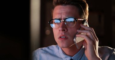 karanlık ofisinde cep telefonu kullanan adam