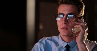 karanlık ofisinde cep telefonu kullanan adam