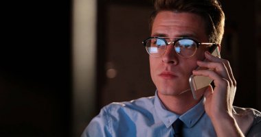 karanlık ofisinde cep telefonu kullanan adam