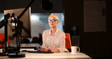 karanlık ofisinde bilgisayarda çalışan kadın