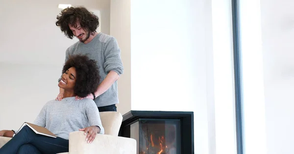 Multiethnic couple hugging in front of fireplace — Stock Photo, Image