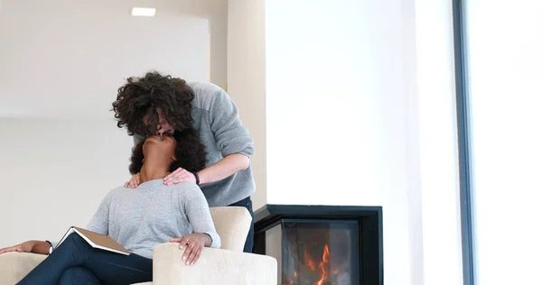 Multiethnic couple hugging in front of fireplace — Stock Photo, Image