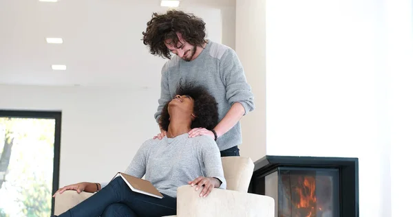 Multiethnic couple hugging in front of fireplace — Stock Photo, Image