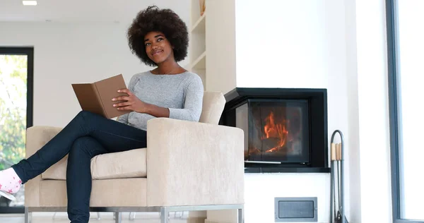 Чорна жінка вдома читає книгу — стокове фото