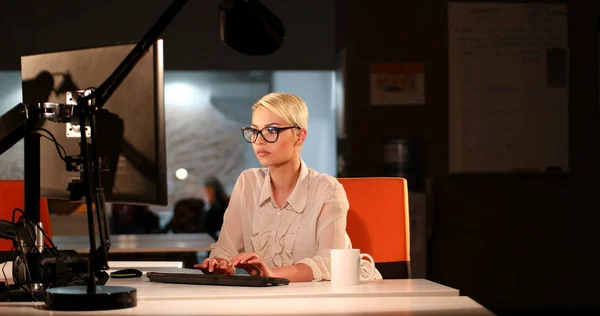 Femme travaillant sur ordinateur dans le bureau sombre — Photo