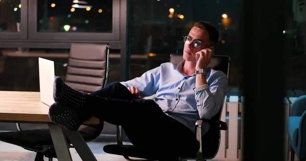 Businessman sitting with legs on desk at office — Stock Photo, Image