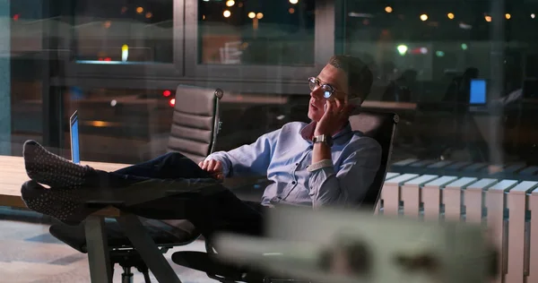 Zakenman zittend met benen op Bureau op kantoor — Stockfoto