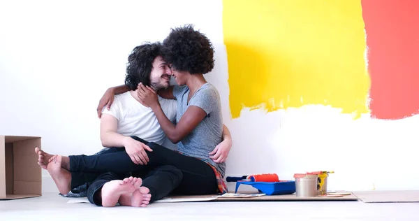 Giovane coppia multietnica rilassante dopo la pittura — Foto Stock