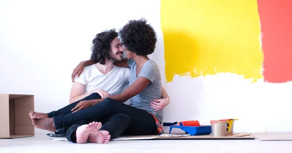 Jovem casal multiétnico relaxante após a pintura — Fotografia de Stock