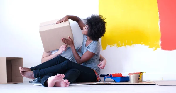 Jovem casal multiétnico brincando com caixas de papelão — Fotografia de Stock