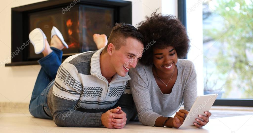 multiethnic couple using tablet computer on the floor