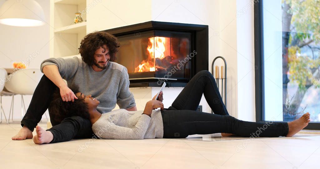 multiethnic couple using tablet computer on the floor