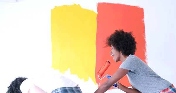 Multiethnic couple painting interior wall — Stock Photo, Image