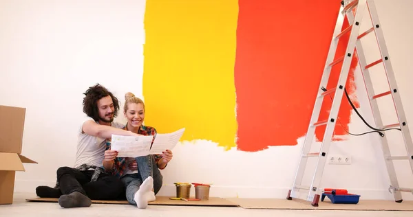 Feliz jovem casal relaxante após a pintura — Fotografia de Stock