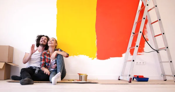 Feliz jovem casal relaxante após a pintura — Fotografia de Stock