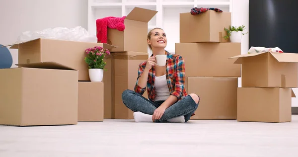 Žena s mnoha lepenkových krabic sedí na podlaze — Stock fotografie