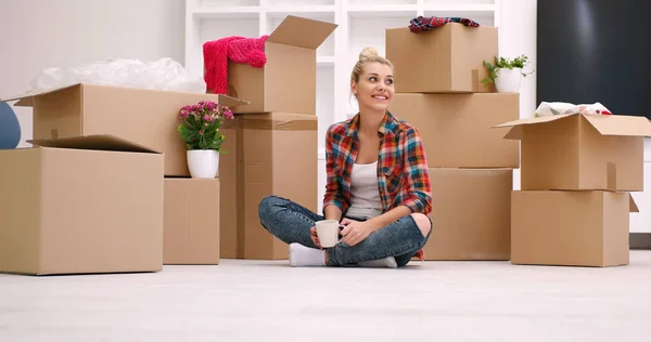 Žena s mnoha lepenkových krabic sedí na podlaze — Stock fotografie