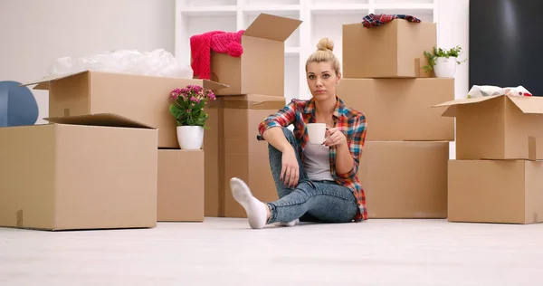 Mulher com muitas caixas de papelão sentado no chão — Fotografia de Stock