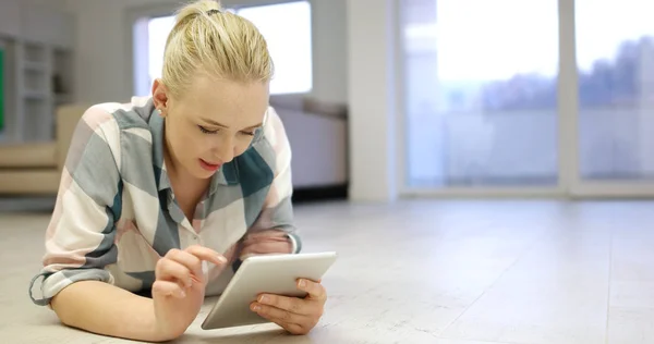 Mujer joven usando tableta en el suelo — Foto de Stock