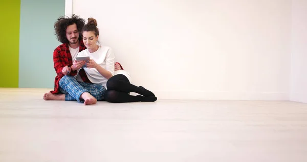 Casal jovem usando tablet digital no chão — Fotografia de Stock