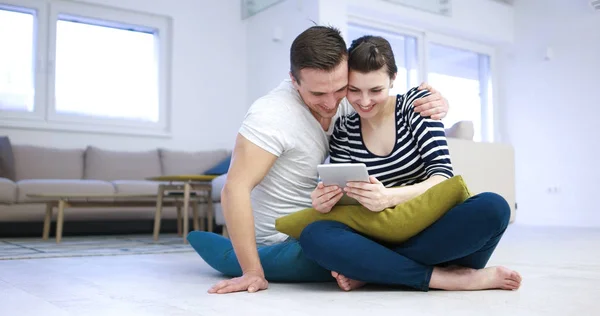 Casal jovem usando tablet digital no chão — Fotografia de Stock