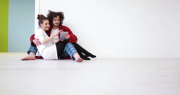 Fiatal pár segítségével digitális tabletta a padlón — Stock Fotó