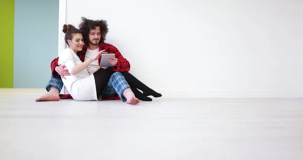 Casal jovem usando tablet digital no chão — Fotografia de Stock