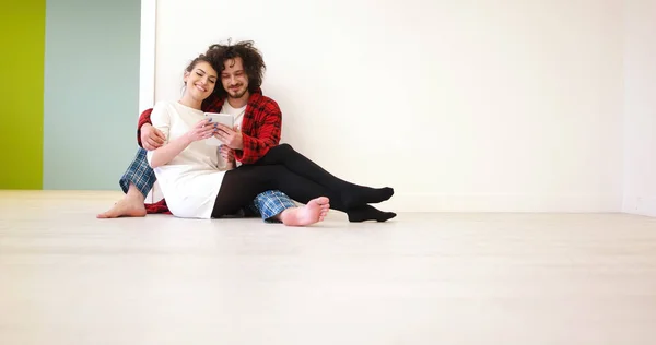 Молода пара використовує цифровий планшет на підлозі — стокове фото