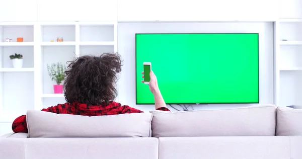 Jovem no sofá assistindo televisão — Fotografia de Stock