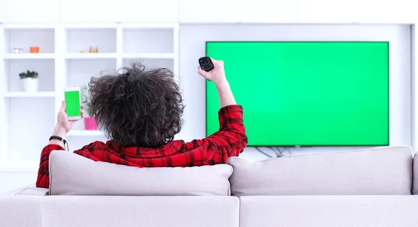 Jovem no sofá assistindo televisão — Fotografia de Stock