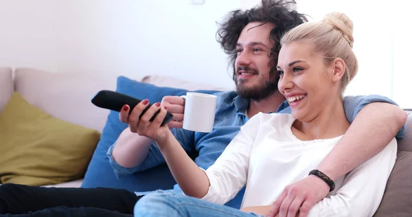 Jeune couple sur le canapé regarder la télévision — Photo