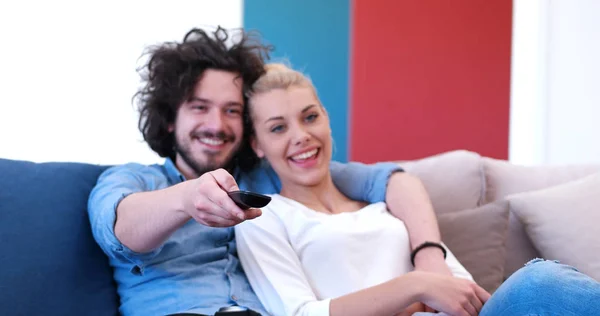 Giovane coppia sul divano a guardare la televisione — Foto Stock