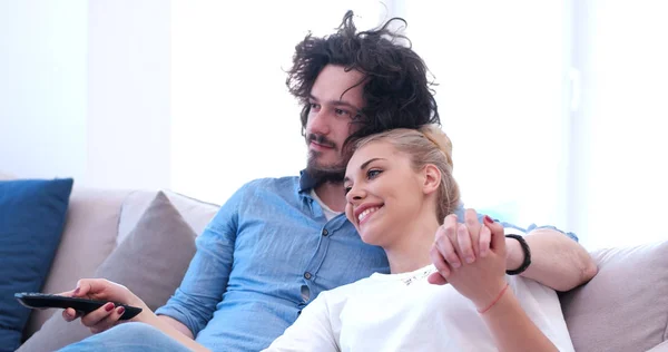 Young couple on the sofa watching television — Stock Photo, Image