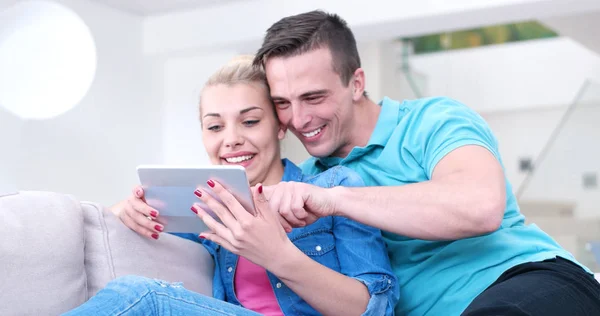 Casal relaxante em casa com computadores tablet — Fotografia de Stock