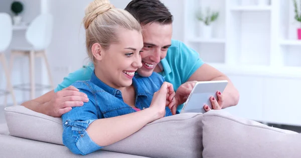 Paar ontspannen thuis met Tablet PC 's — Stockfoto
