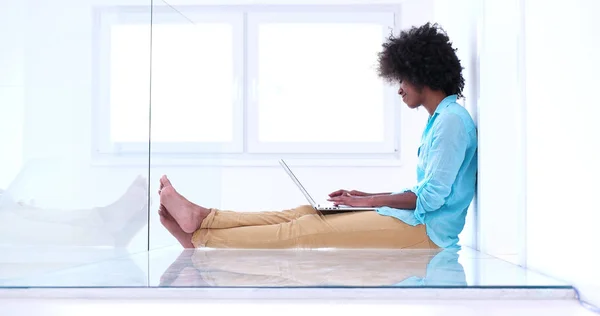 Чорна жінка використовує ноутбук на підлозі — стокове фото