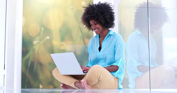 Schwarze Frau benutzt Laptop auf dem Fußboden — Stockfoto
